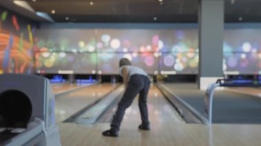 Bowling 'de zaman geçirmek. Pistte paten yapan toplar lobutları devirmek için..