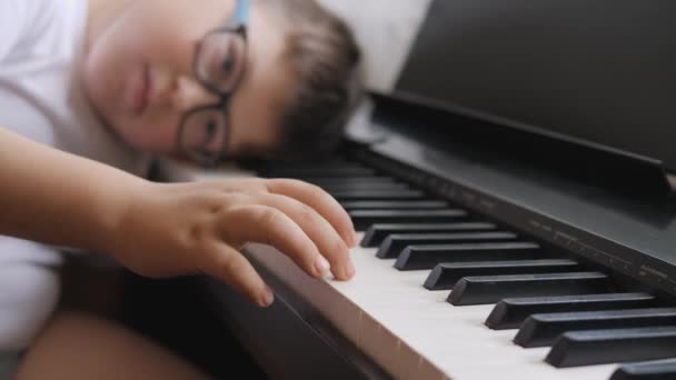 Elektroniskt piano. Fingrarna trycker på pianotangenterna. Musiklektion. Barnet var trött på lektionen och lade sig på instrumentets nycklar. — Stockvideo