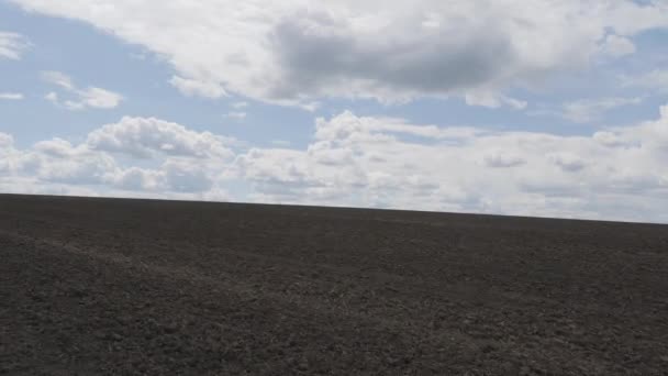 Pole rozciągające się w niebo. Pole jest gotowe do sadzenia ziarna. Chmury unoszące się nad błękitnym niebem. — Wideo stockowe