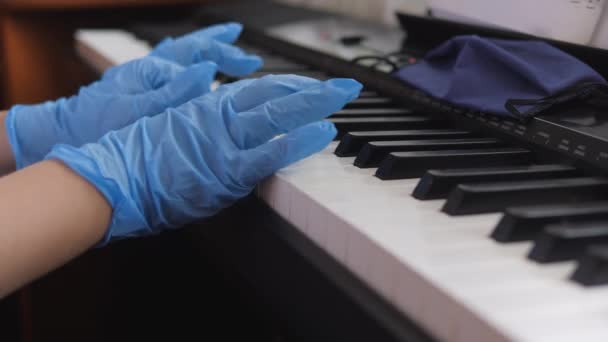 Piano électronique. Les doigts pressent les touches du piano. Mains dans les gants de caoutchouc. Pandémie 2020, auto-isolement . — Video