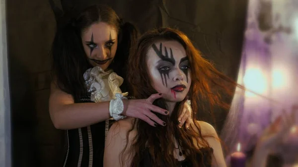 Lätt Halloween makeup. kvinna lägga händerna på de andra flickornas hals. Skräck i en mans ögon. Folks känslor. Flickan med bilden i ansiktet. — Stockfoto