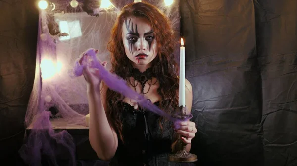 Lehký Halloweenský makeup. Dívka s obrázkem na tváři. Žena drží parafínovou svíčku. — Stock fotografie