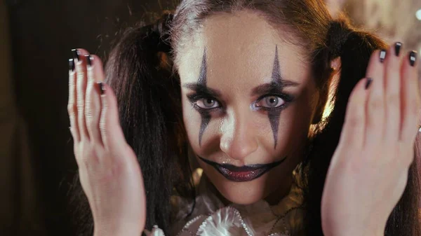 Gemakkelijke Halloween make-up. De vrouw bedekt haar gezicht met haar handen. Het meisje met de foto op haar gezicht. — Stockfoto