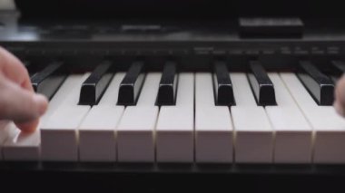Elektronik piyano. Parmaklar piyano tuşlarına bassın. Müzik dersi. Parmaklar bir müzik aletinin tuşlarına basar. Alt görünüm.
