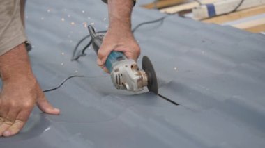 Kum makinesine monte edilmiş bir diskle metal kesimi. Kıvılcımlar farklı yönlere uçar. Bina malzemesinin boyutuna uyuyor. Elle çalışan elektrikli araçlar.
