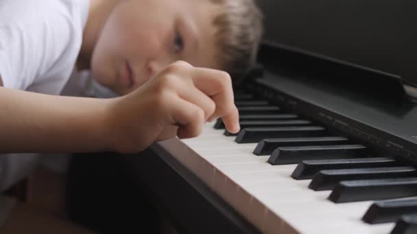 Електронне піаніно. Пальці натискають клавіші піаніно. Музичний урок. Дитина втомилася на уроці і лягла на ключі інструменту . — стокове відео