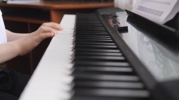 Piano elettronico. Le dita premono i tasti del pianoforte. Lezione di musica. Le dita premono i tasti di uno strumento musicale. Vista laterale. Mani per bambini sulla tastiera del pianoforte. — Video Stock