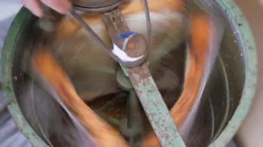 Bal peteğinden balın çıkarılması. Bal sökücü çerçevelerle dönüyor bal petekleri, bal pompalama. Bal peteğinden bal alıyorum, yakın plan. Güç odaklı bir operasyon. Belt sürücüsü. Çıkarıcı. Bal kazanıyorum. ProRes