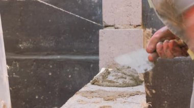 İnşaat işi. Kireç taşı döşeme. Duvarcıların işi. Özel bir araç ile tuğla işi düzeyi.