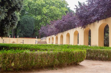 Parkta duvarları ve kemerleri olan çiçekler.