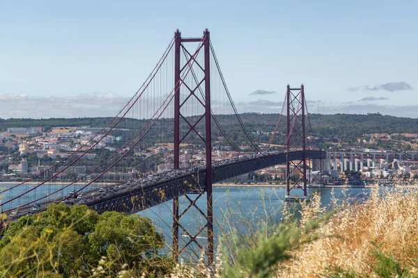 4月25日にリスボンのテジョ川に移動車と橋 晴れた日と近代的な建物の眺め ストック写真
