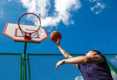 genç adam basketbol avluda bir güneşli yaz gününde