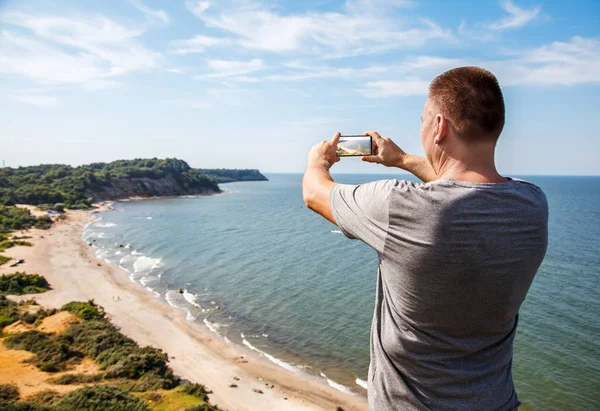 Мужчина Серой Футболке Фотографирует Морской Пейзаж Мобильного Телефона Солнечной Жаре — стоковое фото