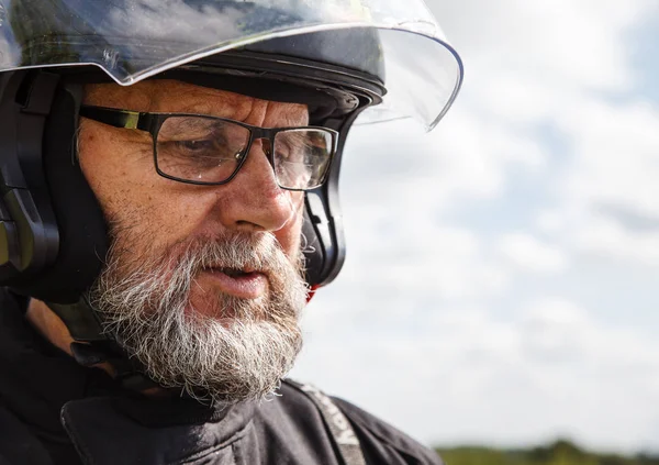 日当たりの良い夏の日の屋外のクローズ アップのジャケットとヘルメットのメガネを着ている高齢者のモーターサイク リストの肖像画 — ストック写真