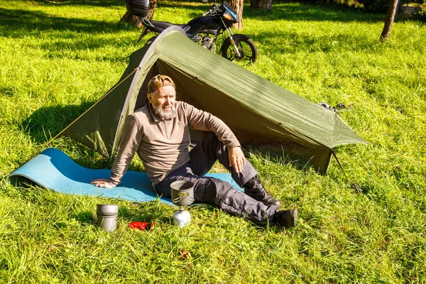 Yaşlı turistik bir çay yakınındaki ormanda çadırını üzerinde güneşli yaz günü soba bir Portable kaynar