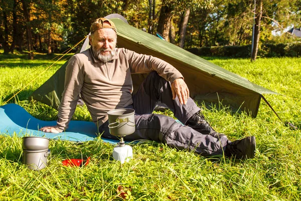 Yaşlı turistik bir çay güneşli yaz gün closeup orman çadırında yakınındaki taşınabilir bir ocakta kaynayan