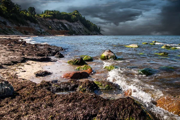 dalgalar deniz büyük bir taş üzerinde bulutlu yaz gününde yıkmak
