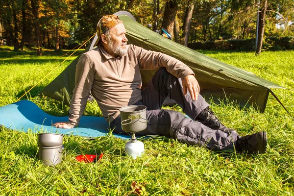Yaşlı turistik bir çay yakınındaki ormanda çadırını üzerinde güneşli yaz günü soba bir Portable kaynar