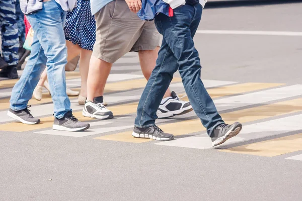 日当たりの良い夏の日に横断歩道での歩行者の足 — ストック写真
