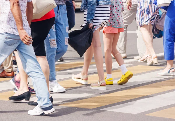 people crossing the pedestrian crossing on sunny summer day