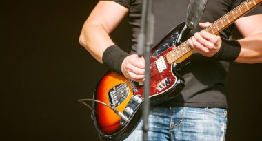 Sahne Alanı'ndaki bir rock konserinde gitarist. Eller yukarı