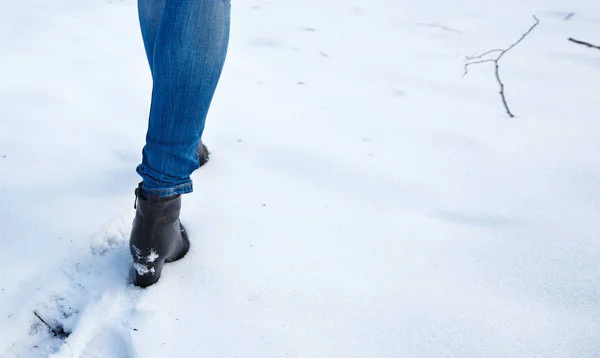 女性ブルー ジーンズと黒靴は雪の足跡を残して 足のクローズ アップ — ストック写真