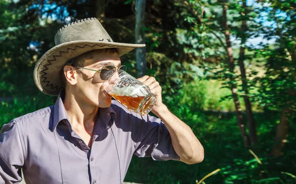 Jeune homme boit de la bière dans le parc — Photo