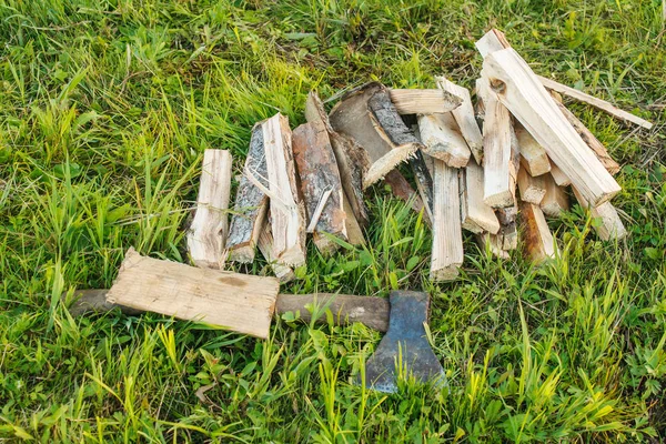 Axt und gehäckseltes Brennholz im Gras — Stockfoto