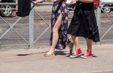 sokakta yürüyen parlak elbiseler içinde iki genç kadın