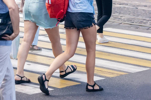 Personas cruzando la calle en el cruce de peatones en soleado — Foto de Stock