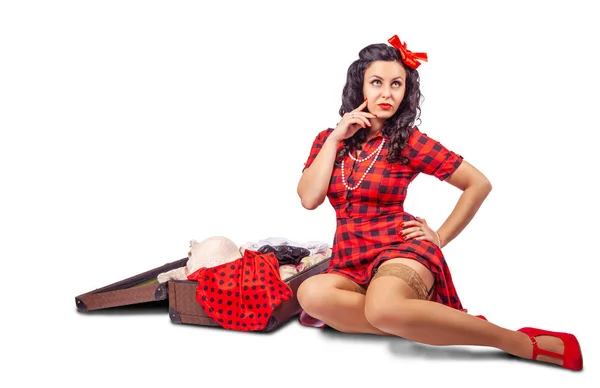 Jonge vrouw zittend op de vloer en het zetten van kleren in een suitca — Stockfoto