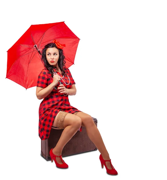 Νεαρή γυναίκα με ομπρέλα pinup στυλ κάθεται σε μια βαλίτσα — Φωτογραφία Αρχείου