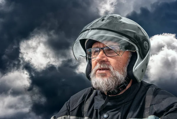 Portrét staršího motocyklista na chmurném tmavém dni — Stock fotografie
