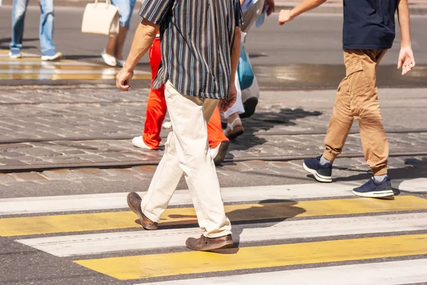 Beine von Fußgängern, die auf dem Zebrastreifen gehen — Stockfoto