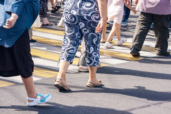 Piernas de peatones caminando en el paso de peatones — Foto de Stock