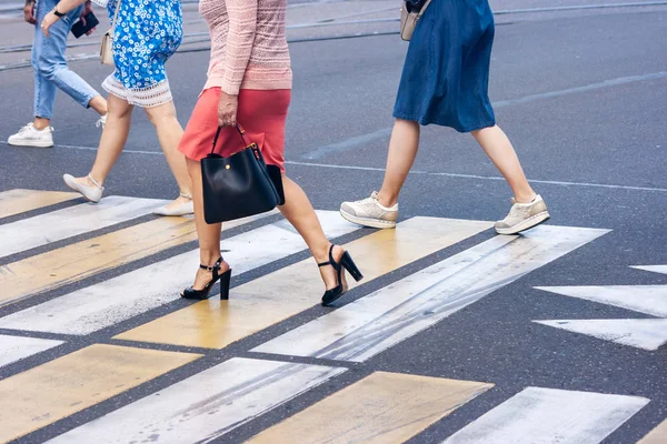 Piernas de jóvenes peatones caminando en el paso de peatones — Foto de Stock