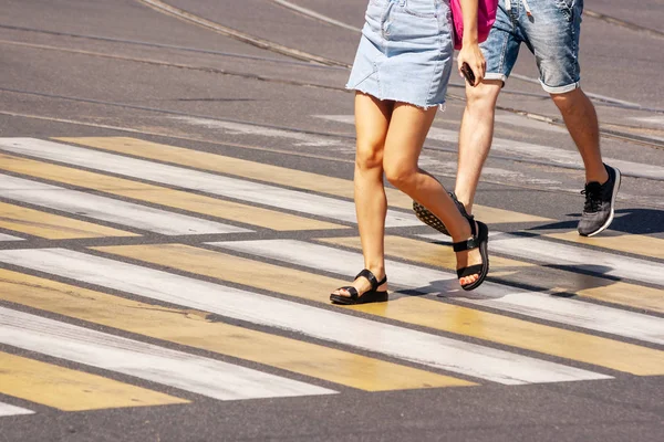 Pernas de jovens pedestres andando no crosswalkl — Fotografia de Stock