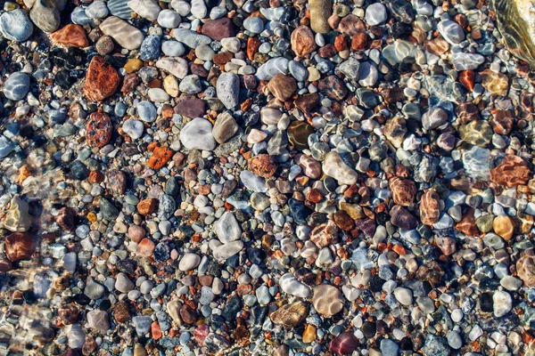 Small multicolored stones under water — Stock Photo, Image