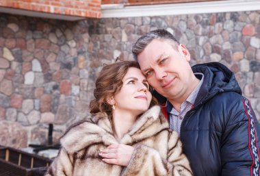 Yeni evliler soğuk bahar günlerinde eski şatonun yanında yürüyorlar.