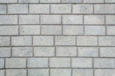 Yol kaldırım fayanslarıyla döşenmiş. Güzel tuğla arka plan, açık gri tuğlaların duvarımsı dokusu. Açık hava yakın çekim