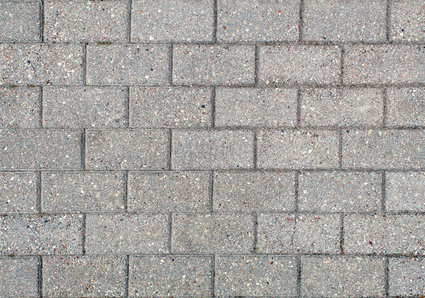 Road paved with sidewalk tiles. beautiful brick background with, masonry texture of light gray bricks. outdoor closeup