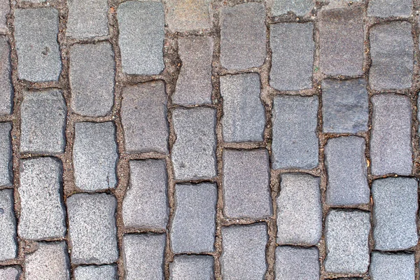 花崗岩の舗装 古い石畳の道の舗装のテクスチャ 石の間の草 抽象的な背景 屋外の閉鎖 — ストック写真