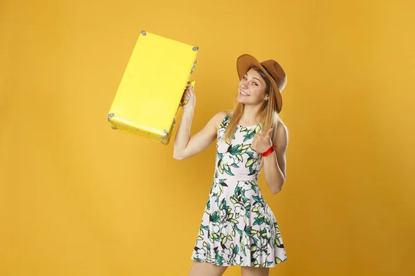 Glückliche Touristin mit gelbem Reisekoffer und Kreditkarte. Studioporträt. Urlaubskonzept. — Stockfoto