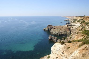 Dağların yakınında mavi denizin güzel bir resmi.