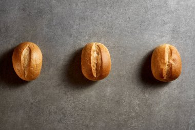 Gri yüzeyde taze pişmiş çörekler. Üst görünüm.