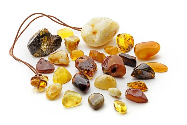 Natural amber. Many pieces of different colors of natural amber on white background. — Stock Photo, Image