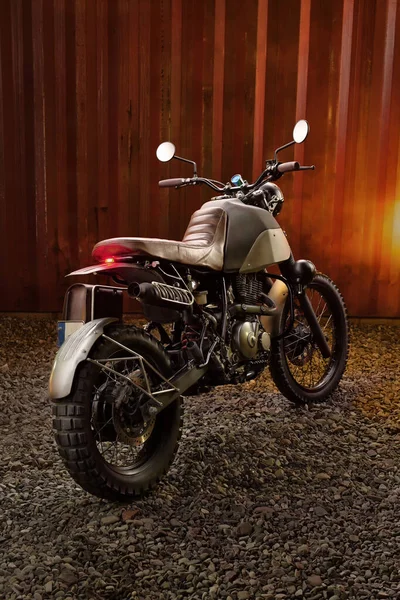 Moto scrambler personalizado sobre un fondo de contenedor oxidado. — Foto de Stock