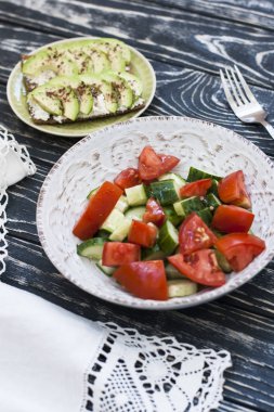 Sağlıklı bir salata taze domates ve sebze ve ev yapımı peynir sandviç, avokado ve baharat sert buğday tost. Sağlıklı bir kahvaltı.