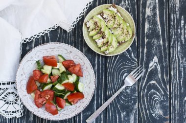 Sağlıklı bir salata taze domates ve sebze ve ev yapımı peynir sandviç, avokado ve baharat sert buğday tost. Sağlıklı bir kahvaltı.