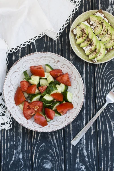 Sağlıklı bir salata taze domates ve sebze ve ev yapımı peynir sandviç, avokado ve baharat sert buğday tost. Sağlıklı bir kahvaltı.